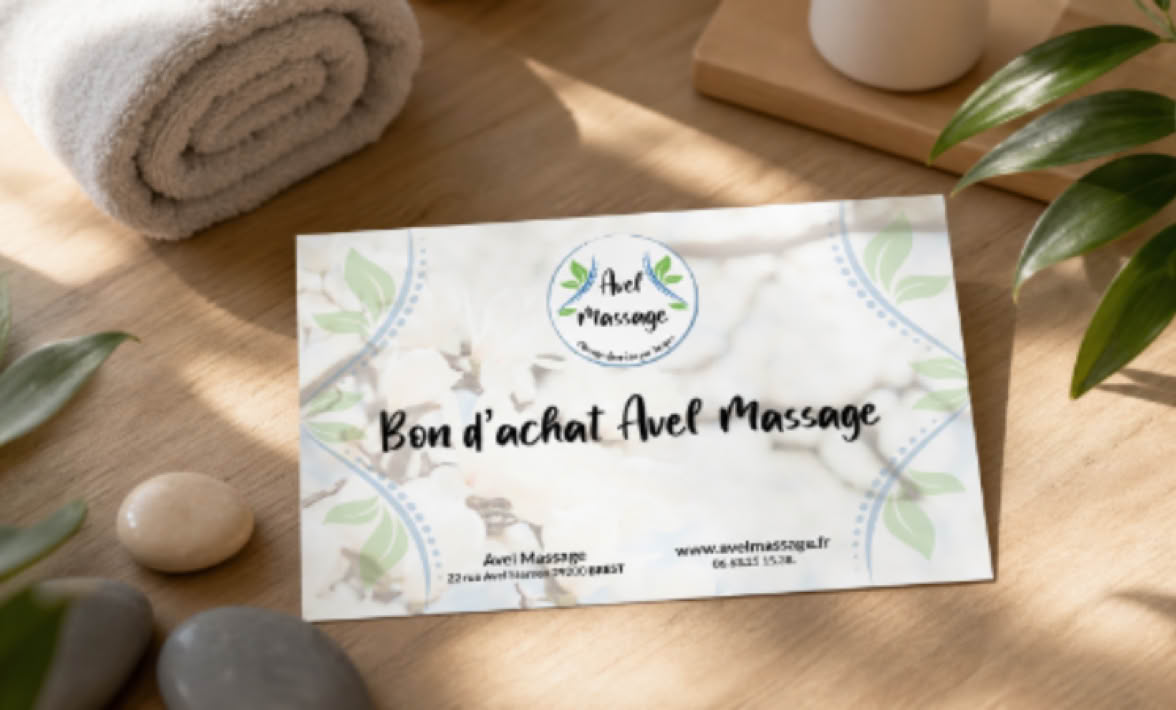 Carte cadeau posée sur une table en bois, entourée de plantes, de galets et d'une serviette roulée.